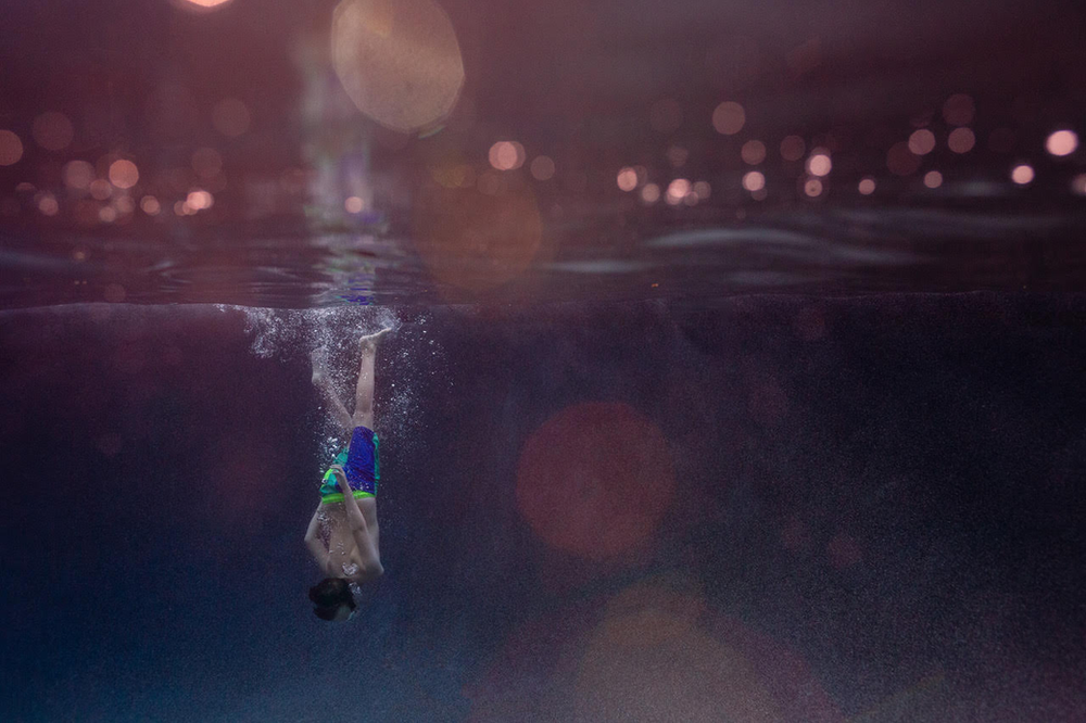 underwater image of a boy diving into water that appears deep