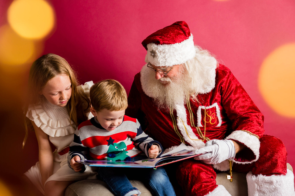 holiday bokeh, girl, boy, book, reading with Santa