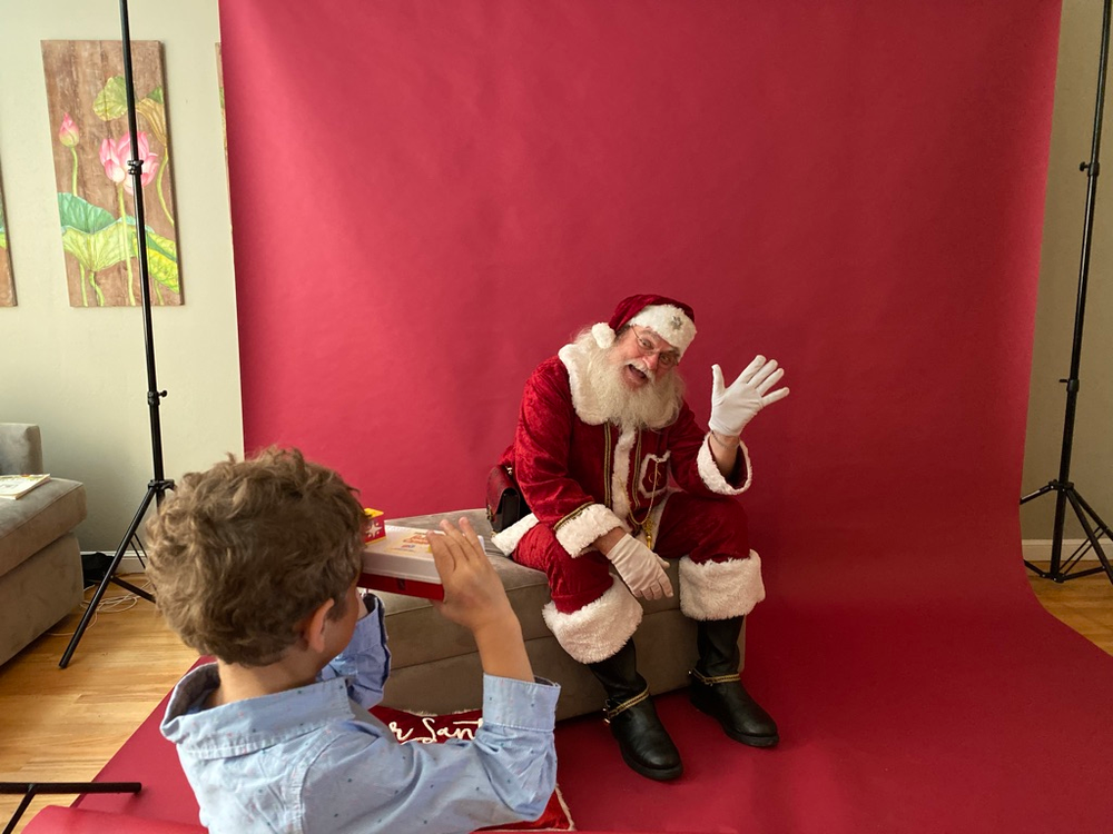 Santa waving to boy, red background, holiday minis background