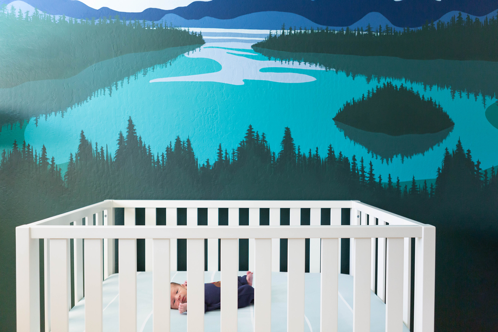 white crib in front of a wall mural of Emerald Cove, Lake Tahoe, nursery