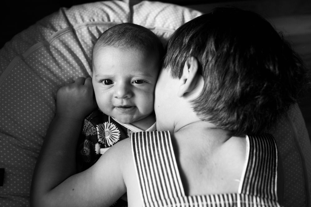 big brother kissing baby sister, black and white