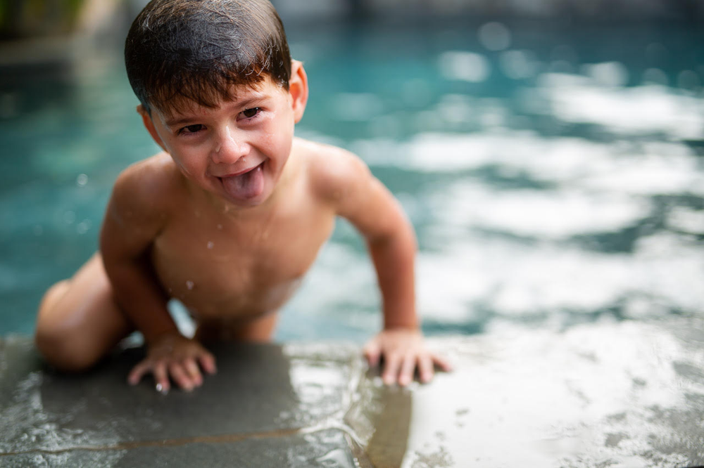 vibrant and colorful image of a little boy climbing out of a pool